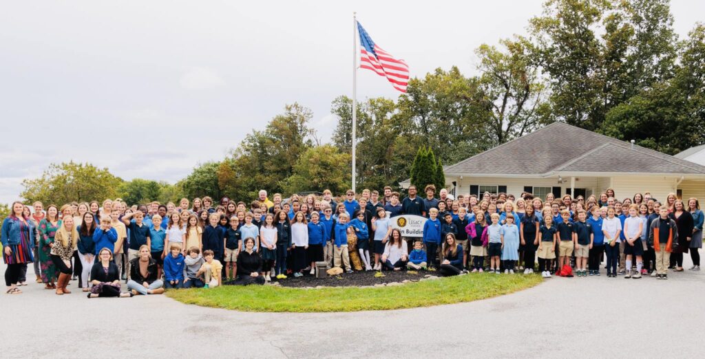 Students and staff gather around the flagpole and Lion Island on The Legacy School, Inc. campus in Sykesville, MD